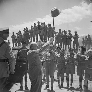 Churchill salutes allied troops in the amphitheatre at Carthage, during a visit to troops near Tunis; IWM NA 3252