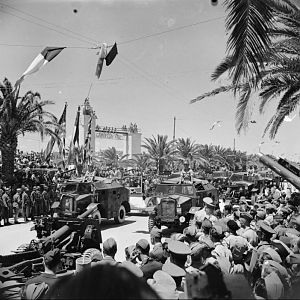 25-pdr guns and 'Quad' artillery tractors parade through Tunis, 20 May 1943; IWM NA 3021